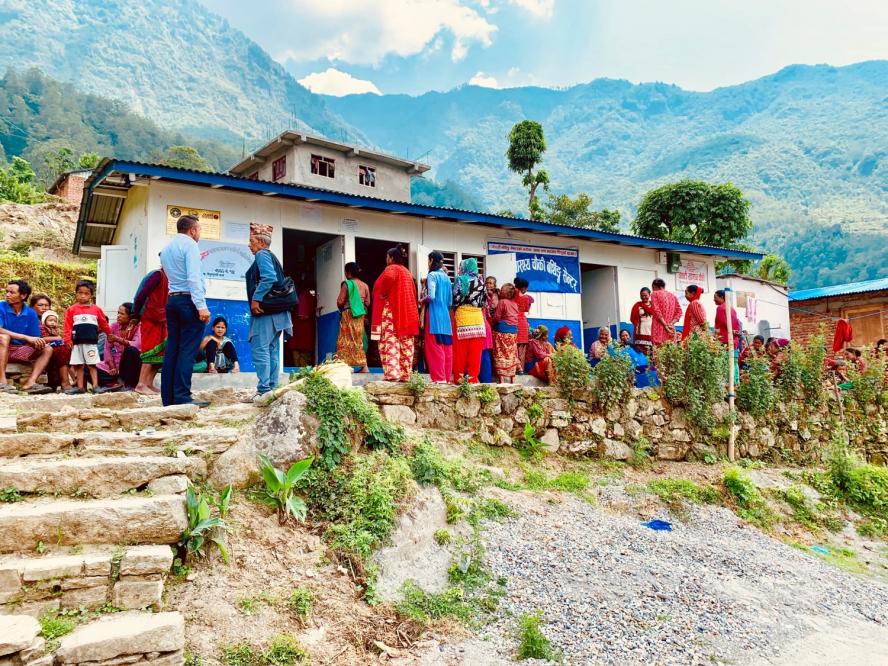 People stand outside of a rural medical clinic in the mountains in Nepal