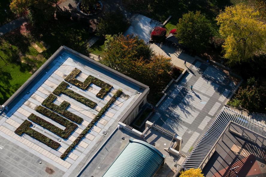 The word Tufts is spelled out in grass and bushes on the roof of the Tisch Library