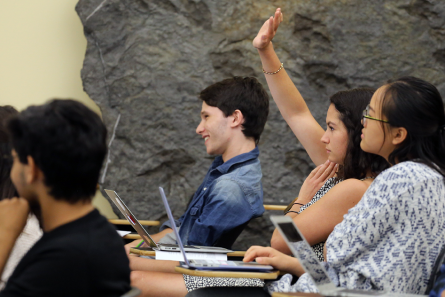 students in a classroom sitting in front of laptops