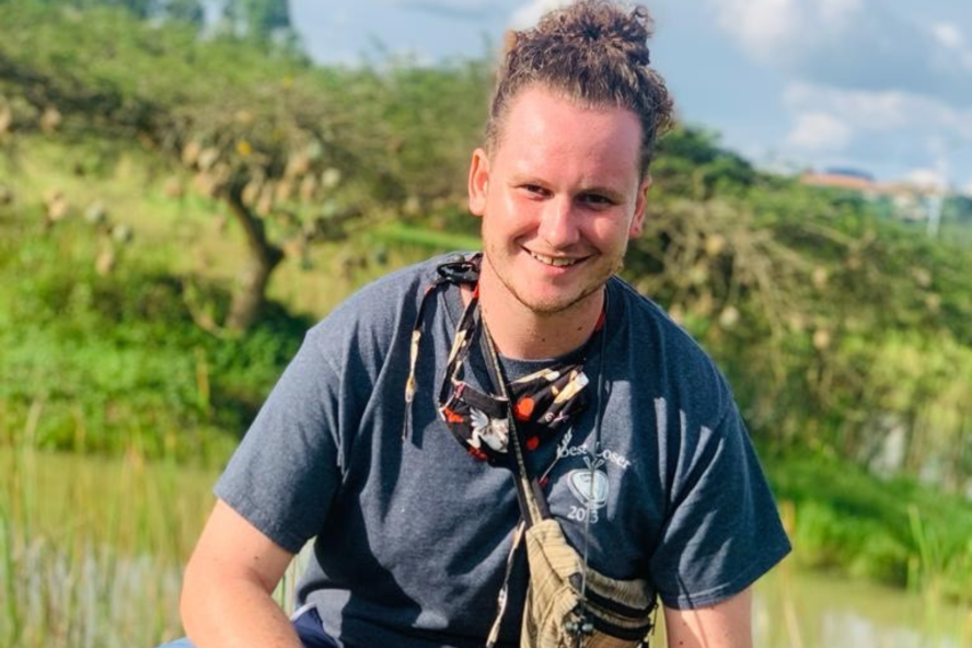 Mikel Quintana poses in a green field in Rwanda 