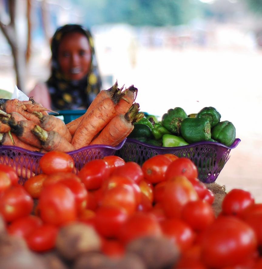 bowls of vegetables sitting on table with a person in the background