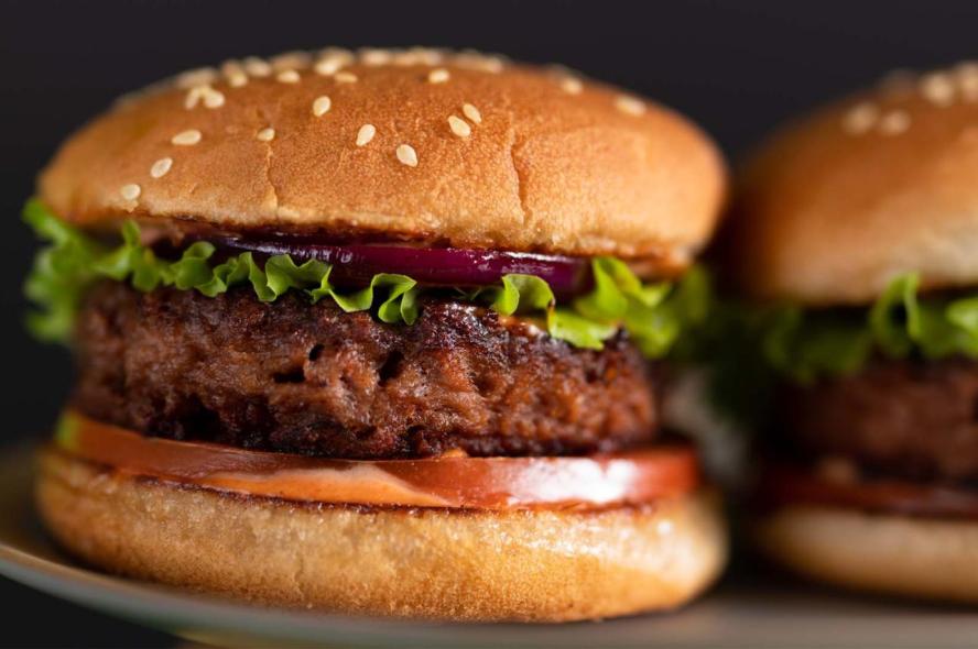 A plant-based meat-substitute patty on a bun with lettuce and tomato 