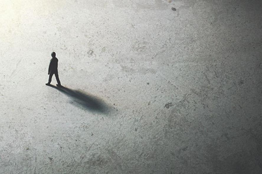 man walking in the night toward the light