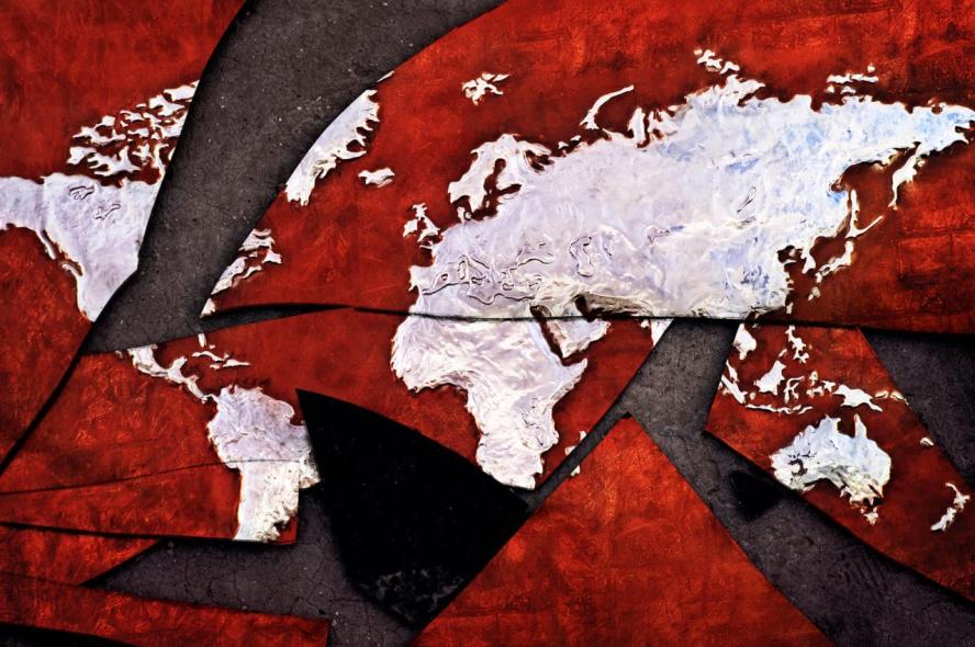 An illustration of a world map, with continents in white against a red background, with pieces of map broken into shards