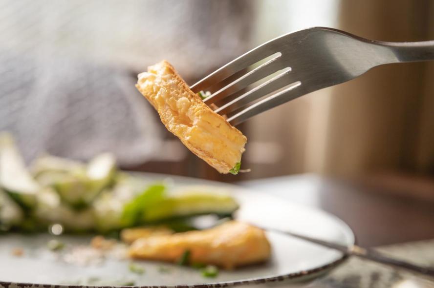 A small bite of omelette on a silver fork