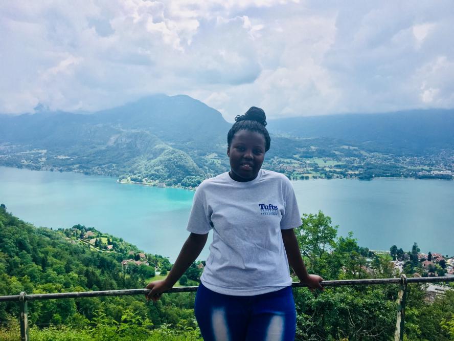 A student poses in front of a lake in France