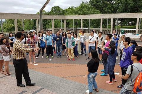 students standing outside listening to an instructor speaking