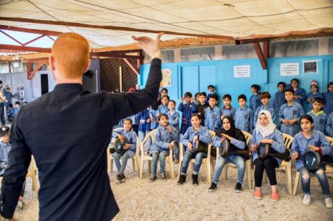 Layth Sidiq, Lecturer of Music at Tufts, conducting a group of Syrian refugee children