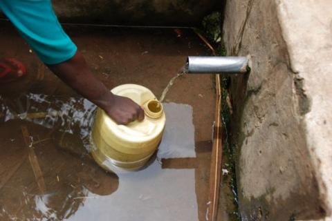 A person fills a plastic jug with water in Kenya