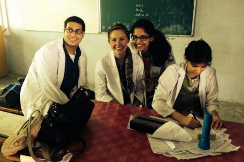 student helps staffers at an Indian health clinic