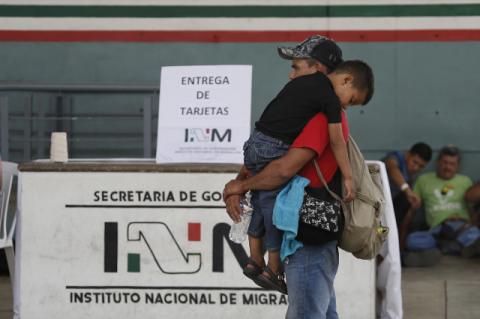 Three Ways to Help Solve the Immigration Crisis A man carries his sleeping three-year-old son past a migration check point. Tufts professors talk about strategies that would help migrants, refugees, and host countries.