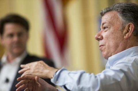 Closeup of Juan Manuel Santos, with another man in the background. Santos tells a Tufts podcast how he fought the odds to create peace in his native Colombia after more than fifty years of war.