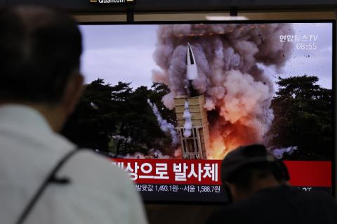 People watch a TV news program reporting North Korea’s firing projectiles with a file image at the Seoul Railway Station. North Korean leader Kim Jong-Un is expanding his arsenal and winning the game of nuclear negotiations with the U.S., says a Fletcher School professor