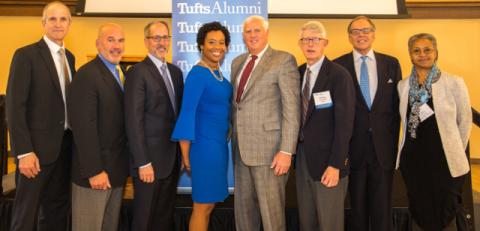 Eight people lined up for a photo. Eight Tufts alumni received awards for their work and service at a ceremony at the university at Homecoming.