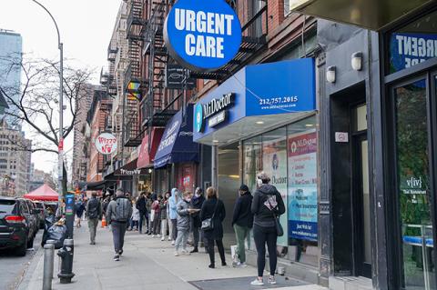 New Yorkers wait outside an urgent care office for Covid-19 testing. Experts at the Tufts 2020 COVID-19 Research Symposium talk about lessons learned from the pandemic. 