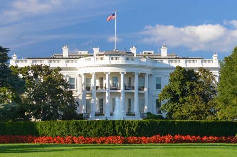 Photo of the White House on a sunny day against a blue sky