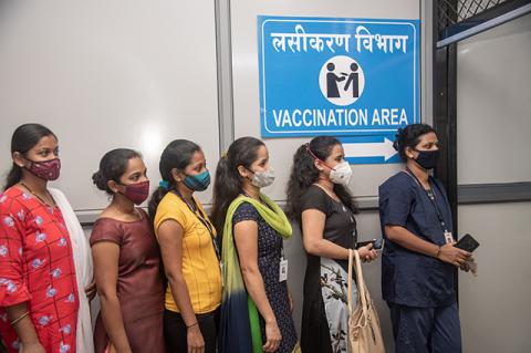 Police and health care workers line up to register for the COVID-19 vaccine at a hospital in Mumbai, India. Vaccine nationalism threatens to delay the end of the pandemic.