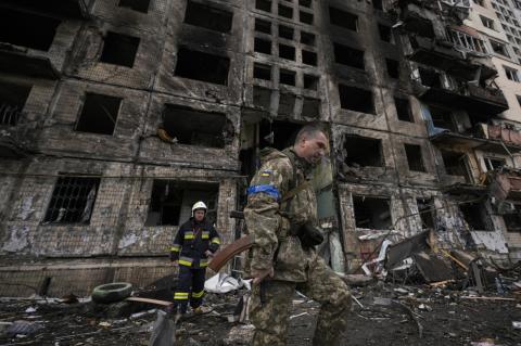 Ukrainian soldiers and firefighters search in a destroyed building in Kyiv. With Ukrainian resistance to the invasion much stronger than expected, the conflict’s future is uncertain, Tufts experts say