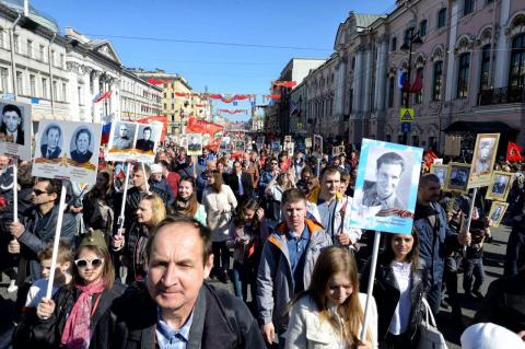 A crowd of people carrying posters of black and white photos of war veterans in St. Petersburg, Russia. Understanding how embedded war is in Russia’s view of itself may help us understand the invasion of Ukraine, says the Tufts expert