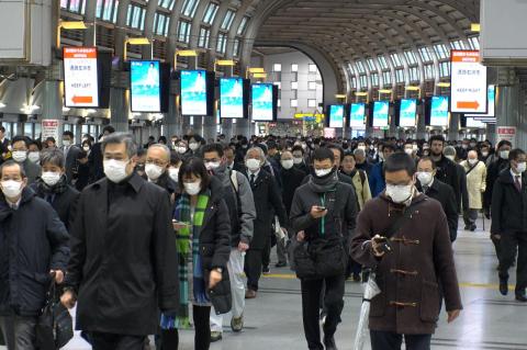 A crowd of people wearing masks at Shinagawa station in Tokyo, Japan