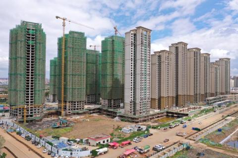 A construction area with many high rise apartment buildings, with cranes rising from some of the buildings. Increased state intervention in the Chinese economy has led to productivity declines 