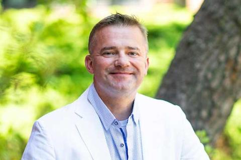 ‘It’s About Choosing the Hard Right Over the Easy Wrong’ A photo of a man in a white jacket sitting on a wooden bench
