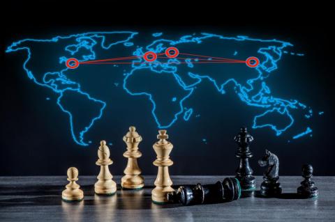 A map of the world in outline against a black background, with links between the U.S, Ukraine, Russia, and China, with chess pieces in the foreground