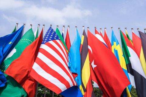 A number of flags flying close together, including the U.S. flag