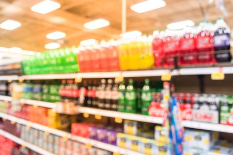 A blurred photo of a soda aisle at a grocery store