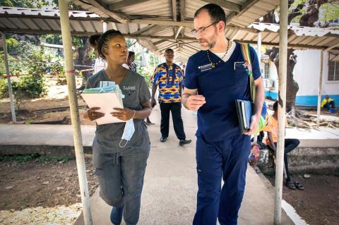 Lloyd Williams has a conversation with a colleague while walking along a pathway.