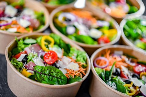 Bowls of colorful salads being prepared