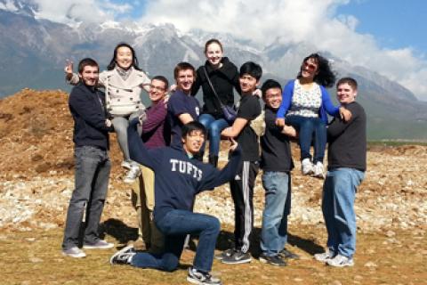 Tufts students in China standing in front of a mountain range