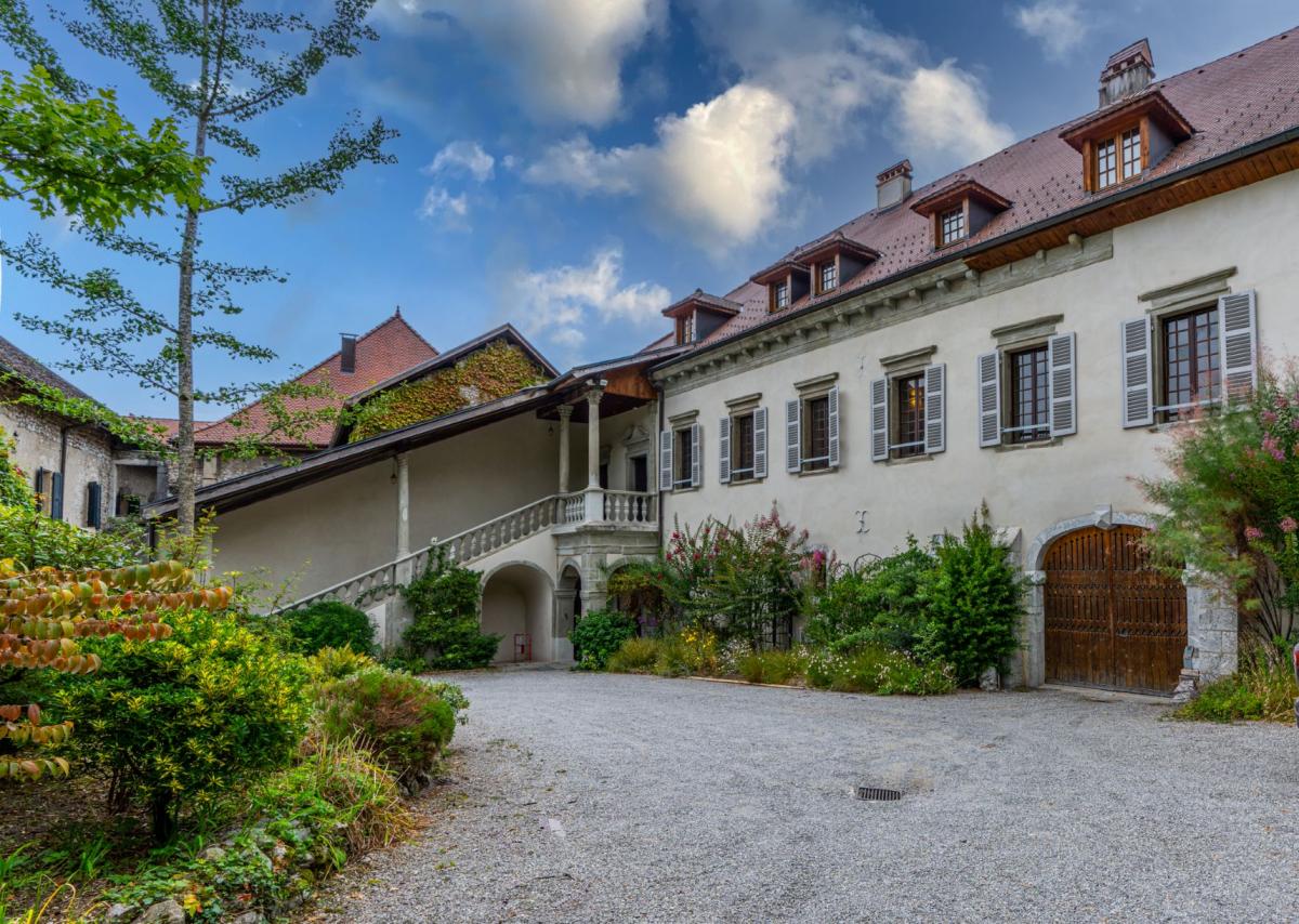 Tufts in Talloires campus photo, showing large white priory building surrounded by gravel driveway and garden