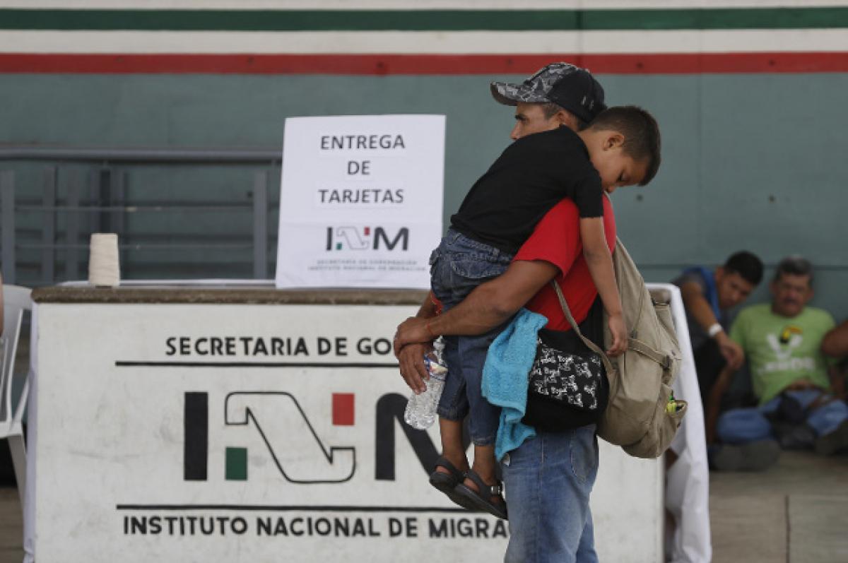 Three Ways to Help Solve the Immigration Crisis A man carries his sleeping three-year-old son past a migration check point. Tufts professors talk about strategies that would help migrants, refugees, and host countries.