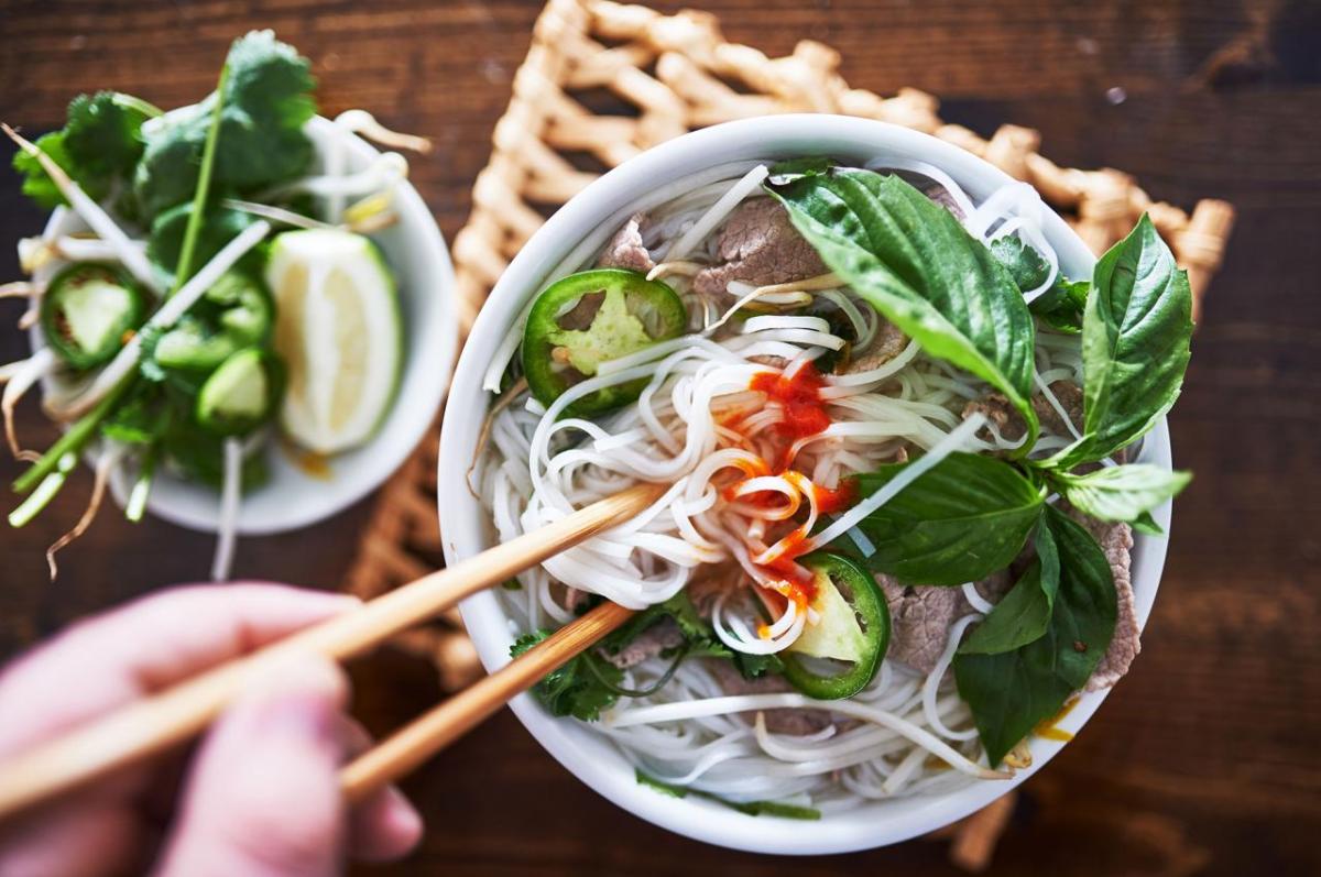 Globally, Diets Are Not Much Healthier Today Than They Were 30 Years Ago A bowl of Vietnamese pho with sriracha, jalapenos, lime wedges, and chopsticks