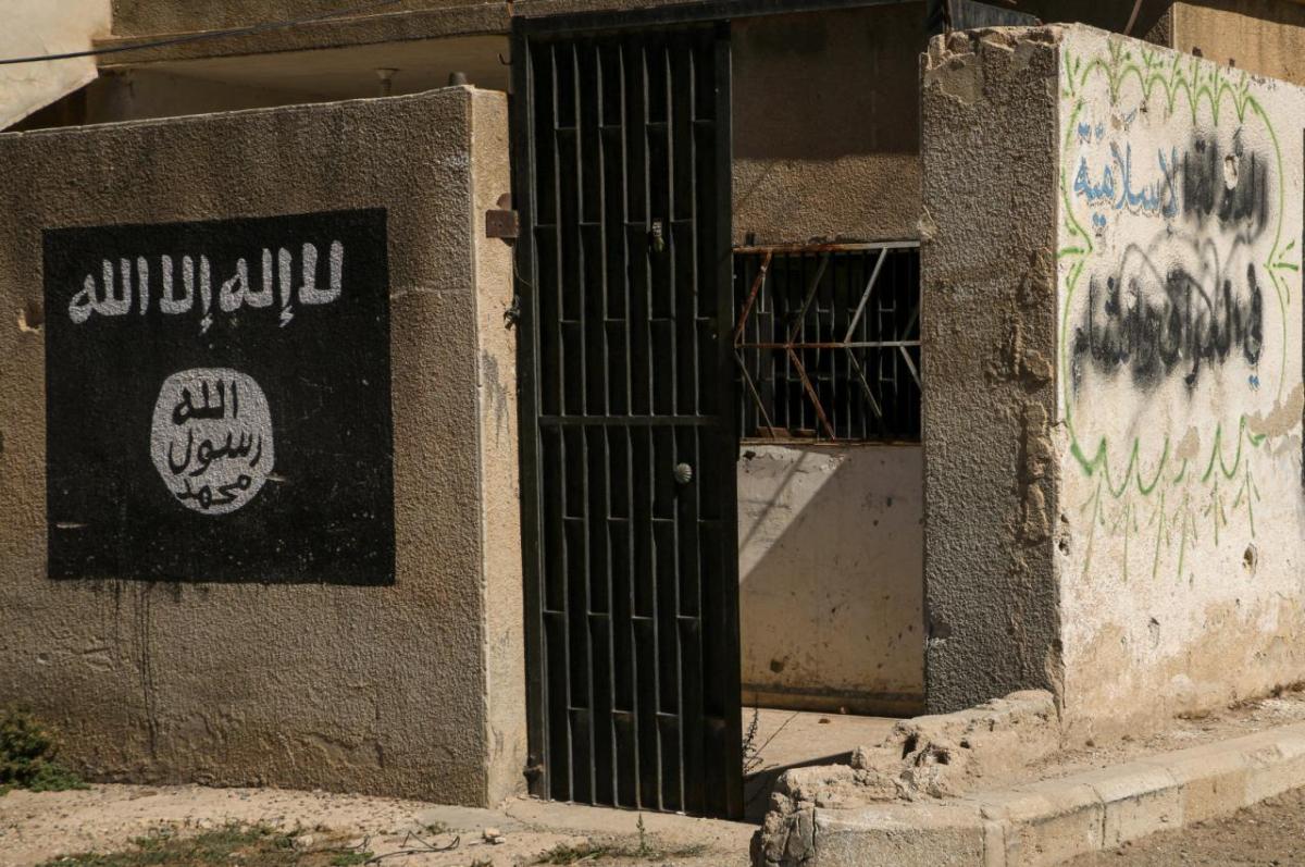 Damaged exterior of a building with black ISIS slogans painted on it in Aleppo, Syria. Conflicts between Muslim groups in the Middle East are rooted in recent history, rather than religious beliefs, according to a new book.