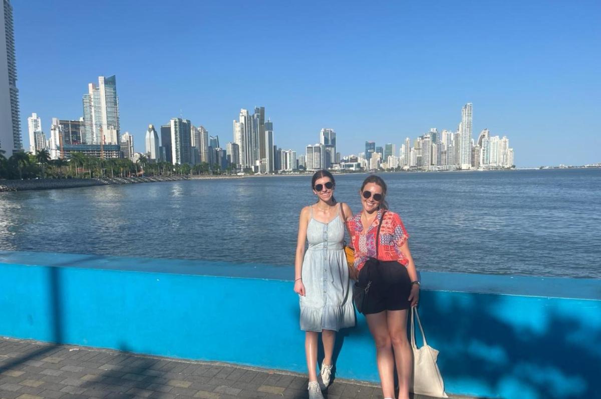 Jessica Simon and Jacqueline Mosher stand in front of the Panama City skyline.